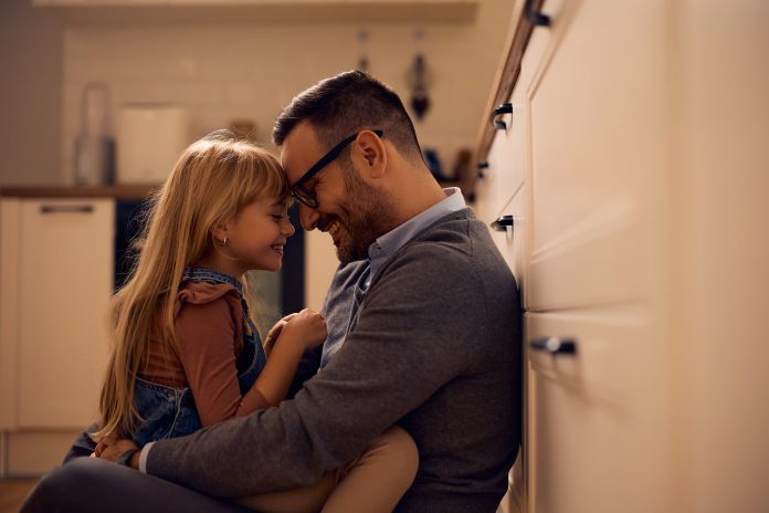 Affectionate,Father,And,Daughter,Sitting,Face,To,Face,While,Relaxing